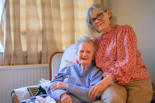 Elderly woman being supported by carer at home