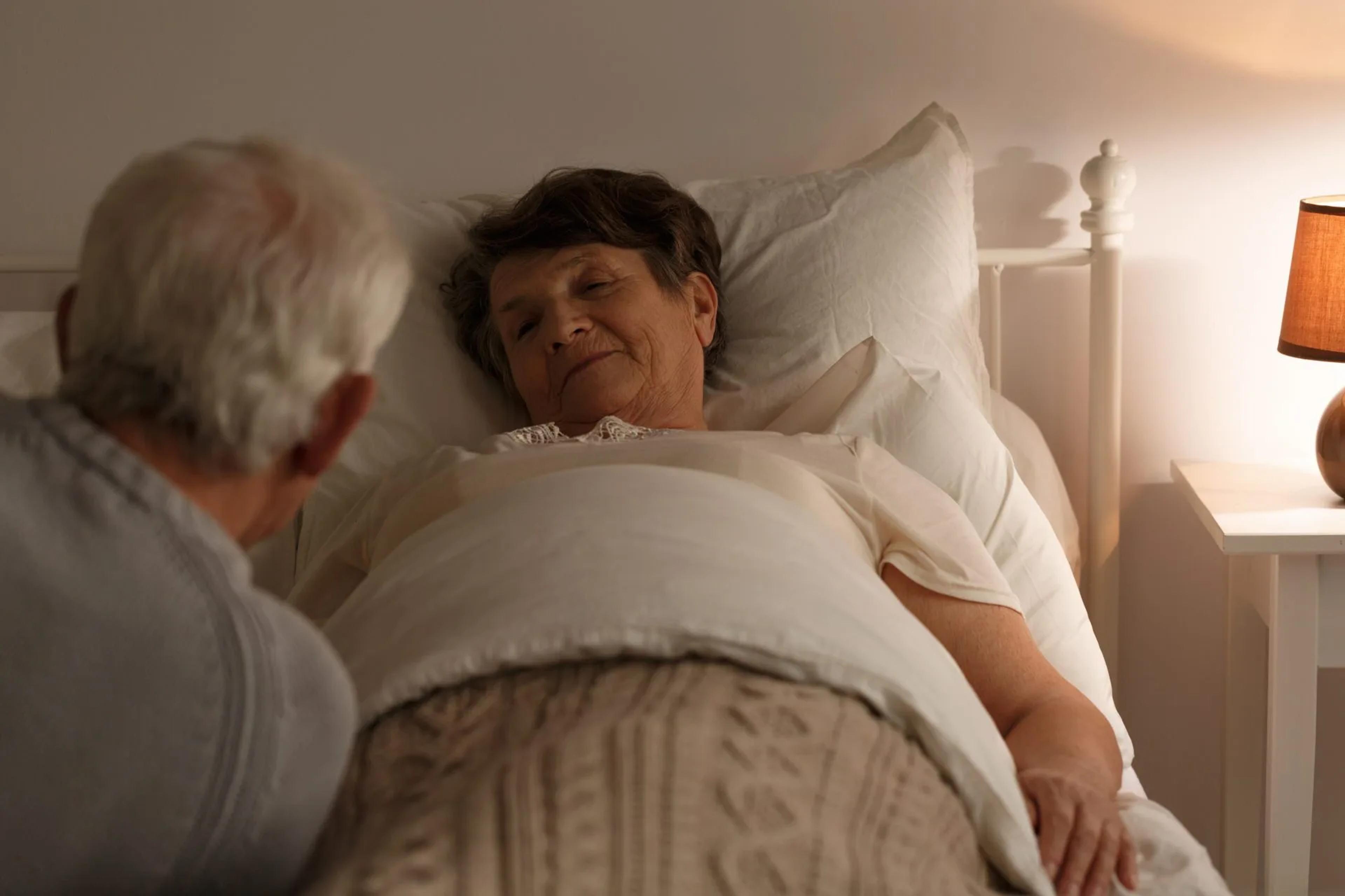 Carer looking after elderly woman at night