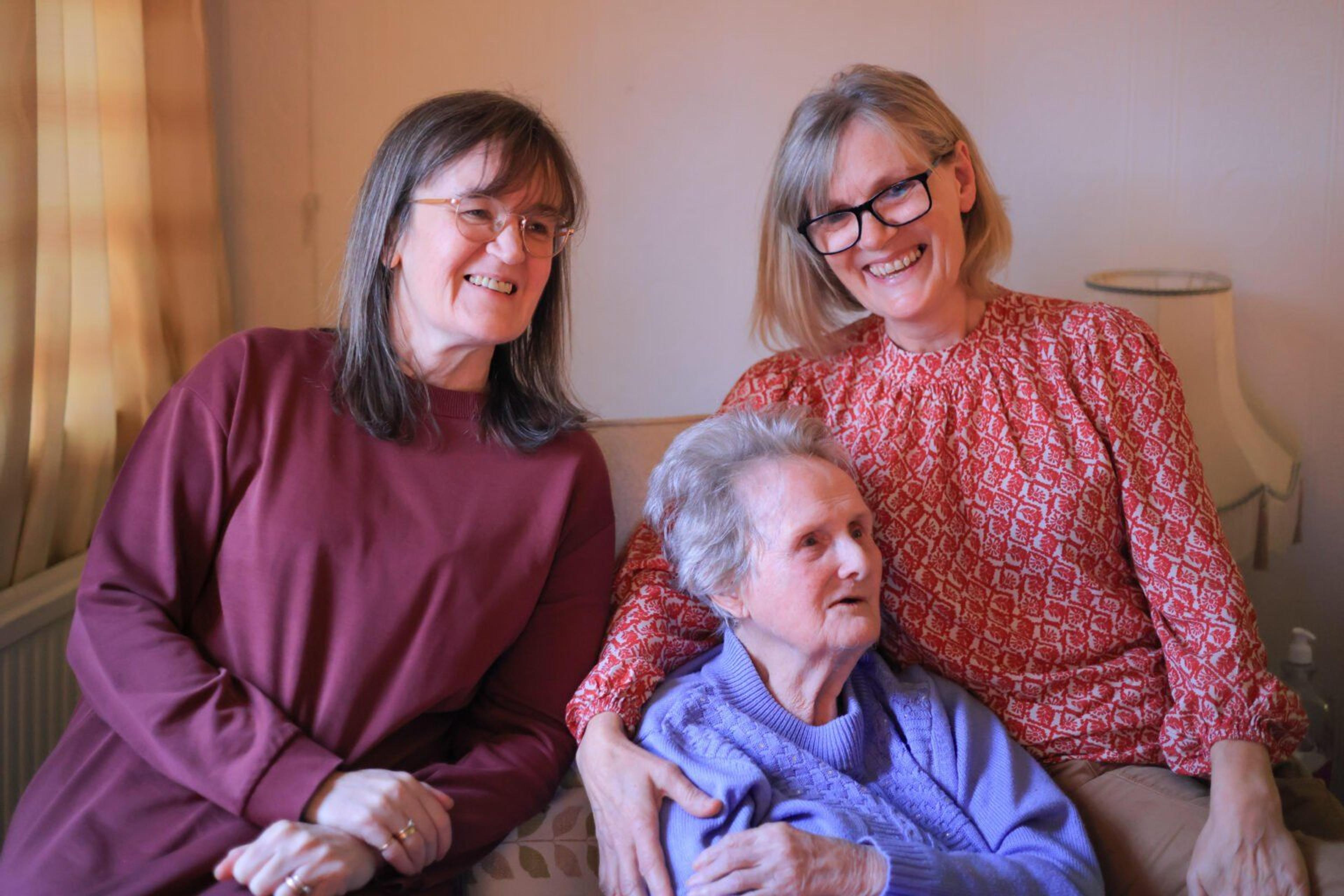 Elderly woman with her carer and daughter