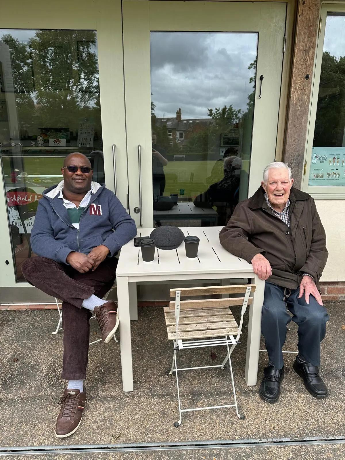 Bob having coffee with his carer Godswill