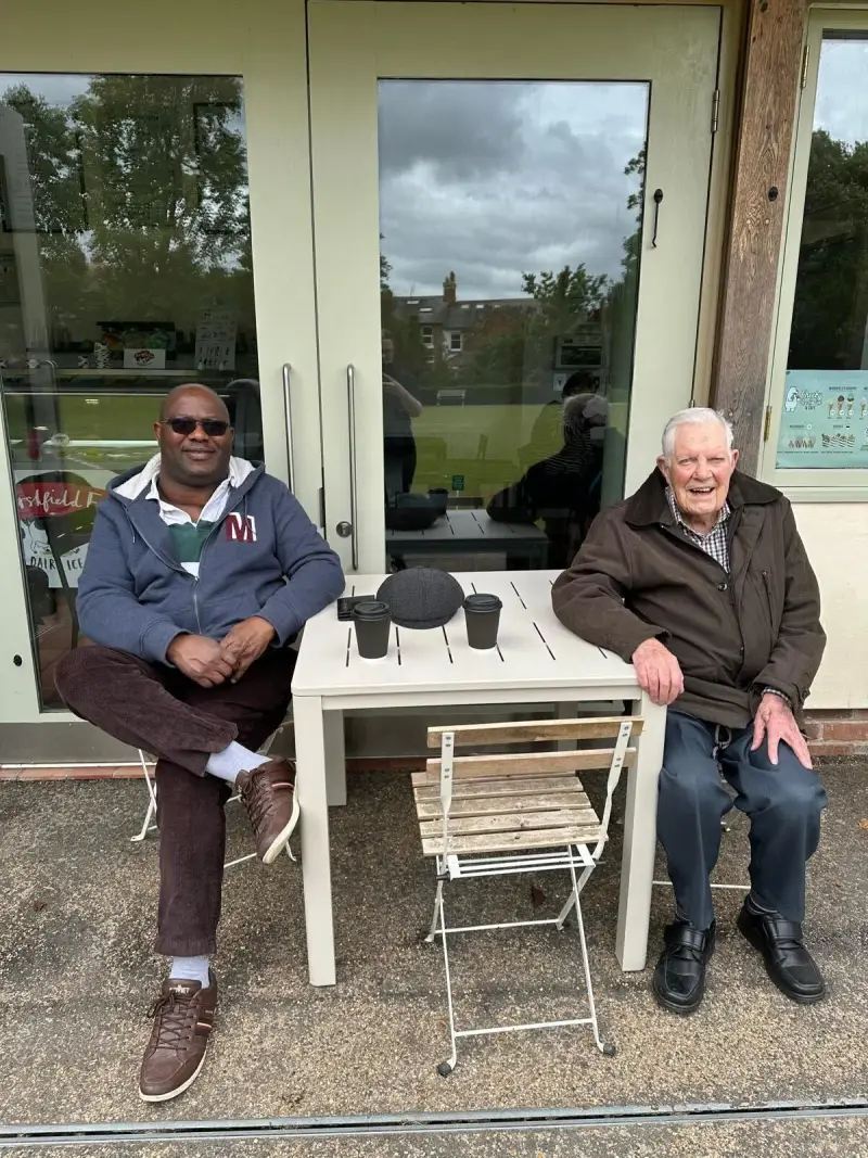 Bob having coffee with his carer Godswill