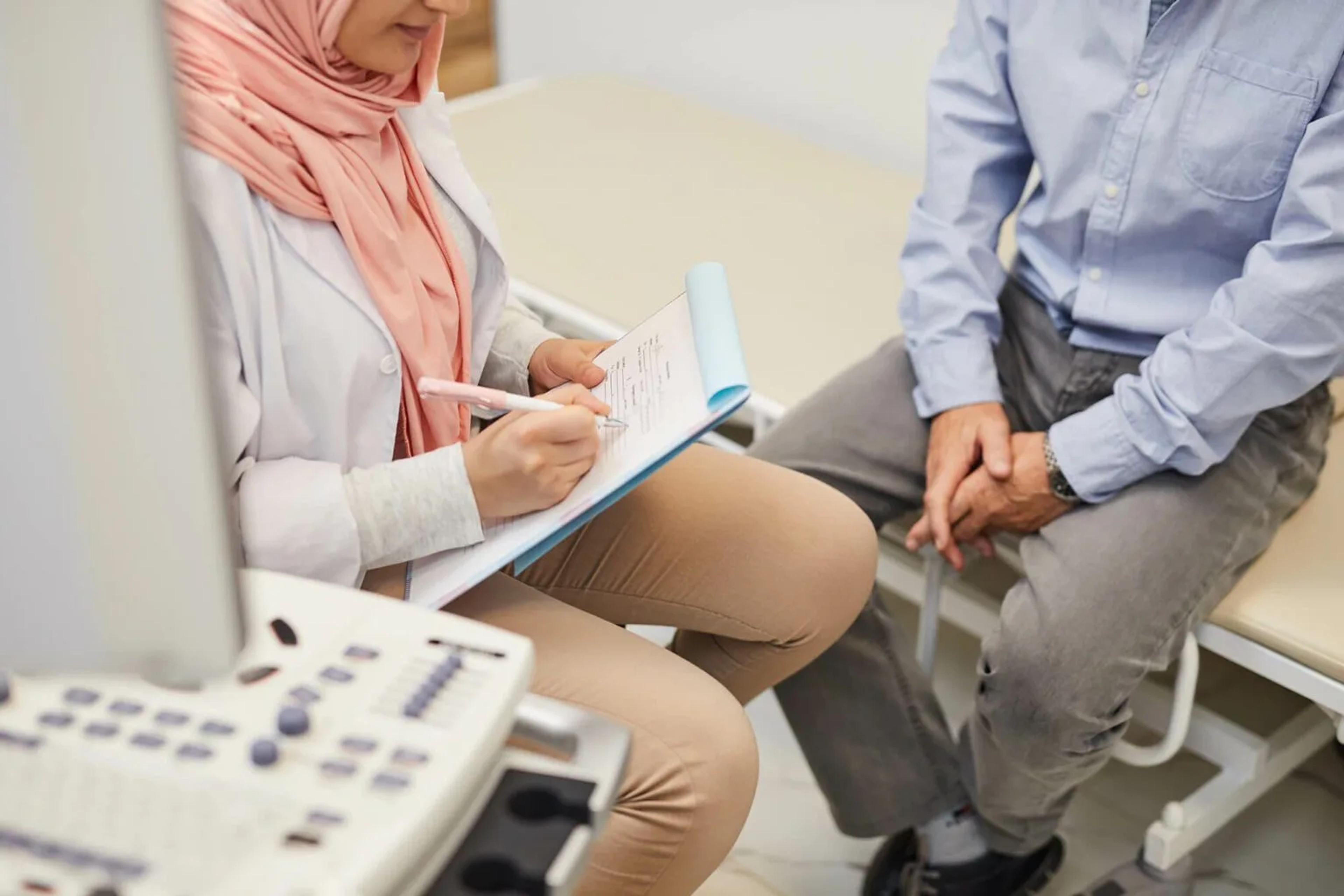 doctor speaking with elderly patient and taking notes