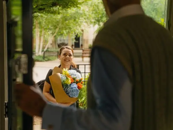 Carer arriving with flowers at the home of an elderly man