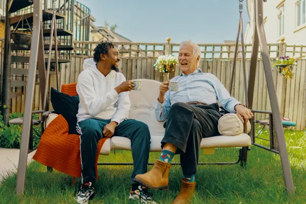 Carer and elderly man sat in the garden
