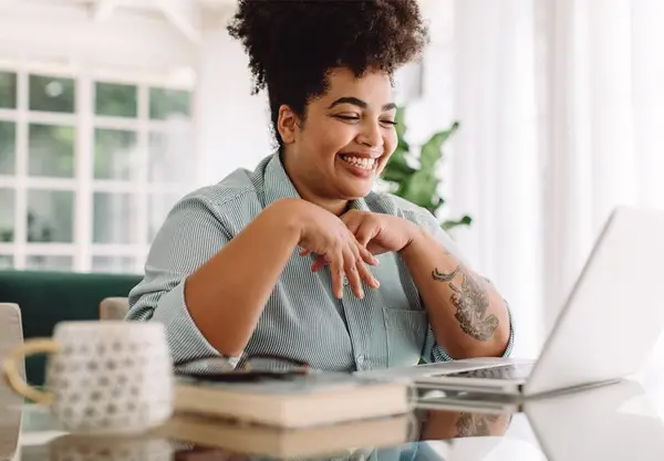 A carer smiling whilst working on her computer