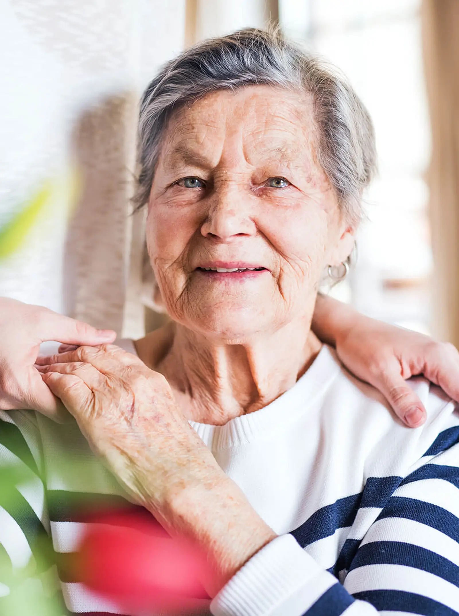 An elderly person playing the piano and a carer is listening