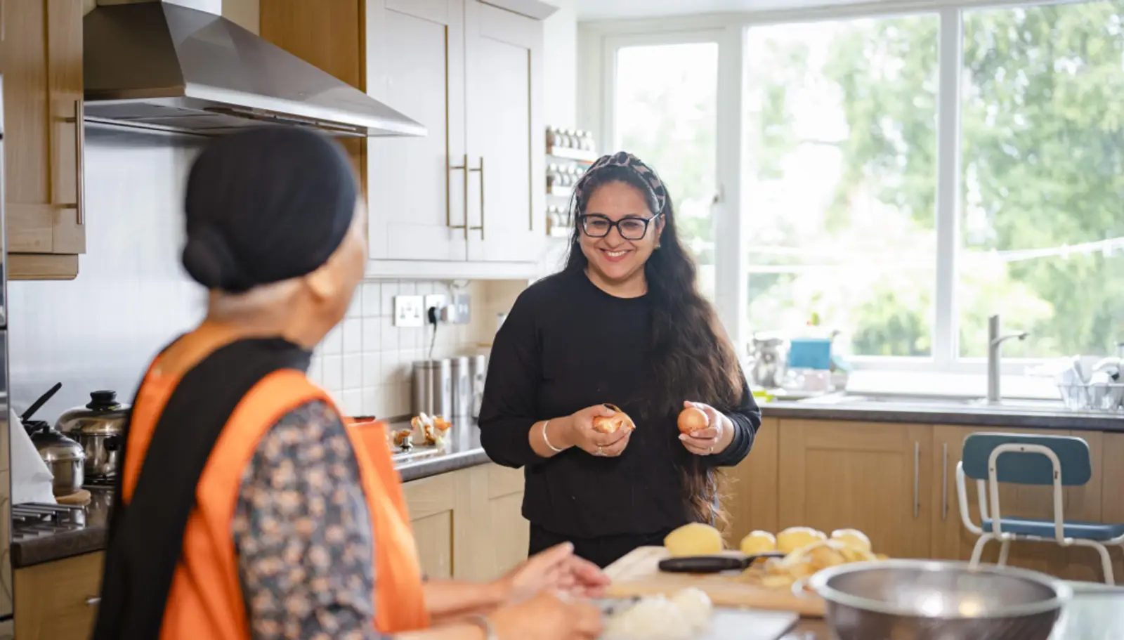 Carer helping elderly woman in the kitchen