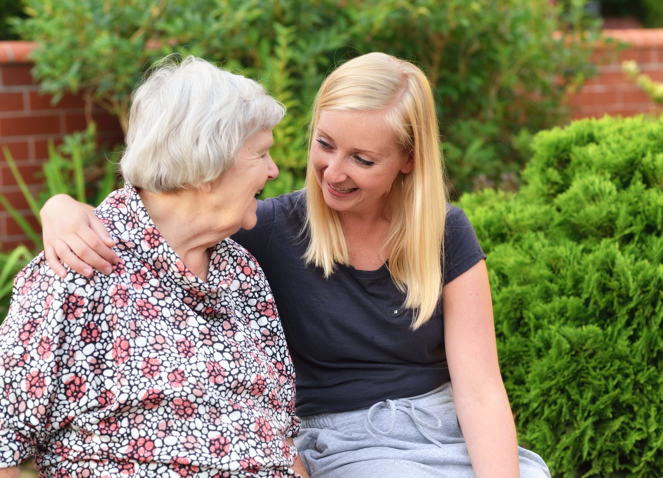 Elderly woman and her carer in the garden