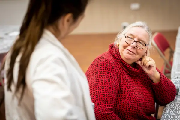 An elderly woman listening
