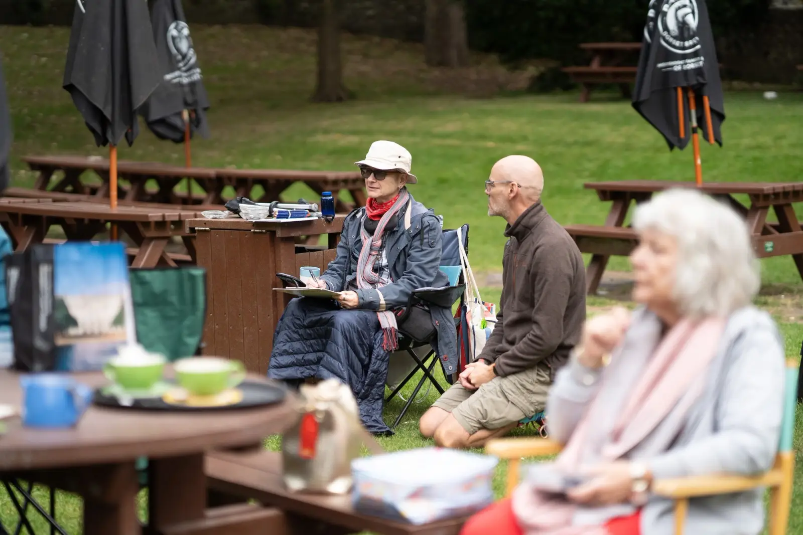 Group of elderly people sitting at tables outside