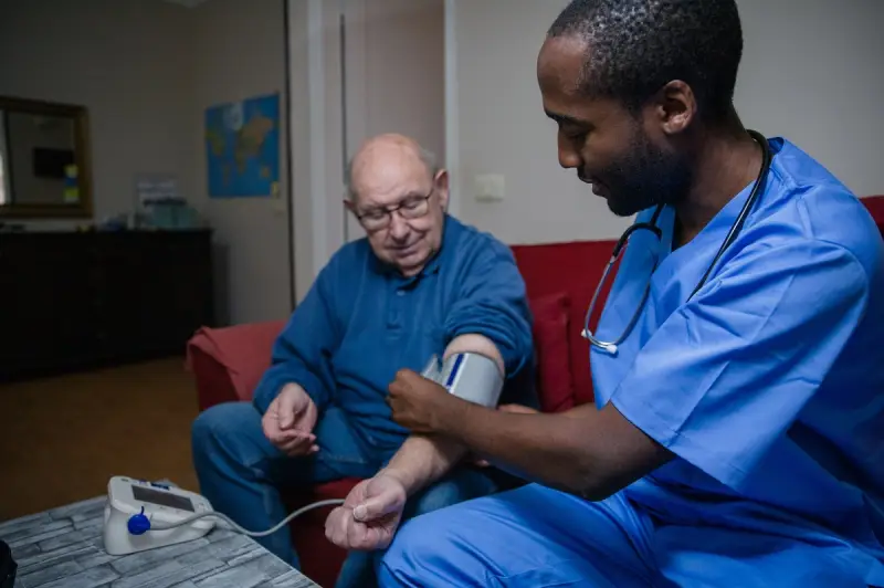Doctor taking blood pressure of elderly patient
