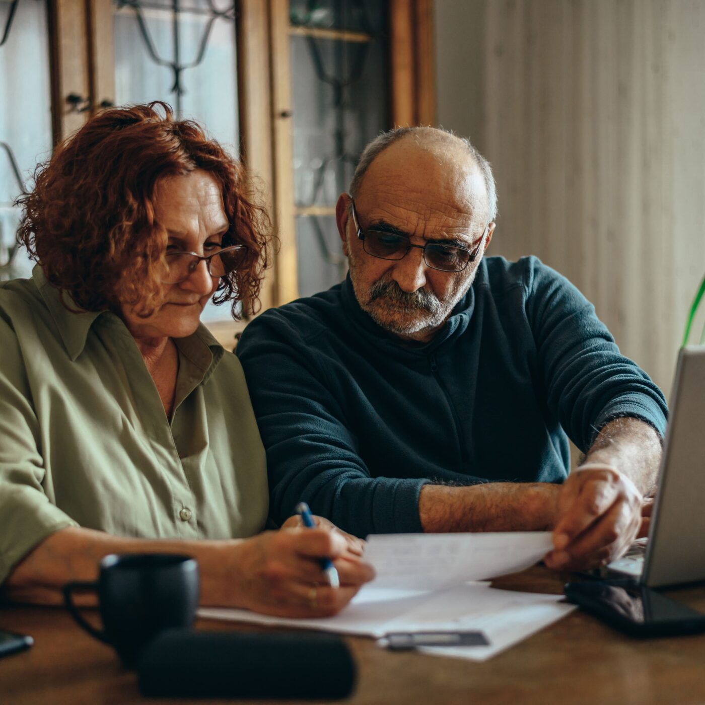 Two elderly people looking at documents together 