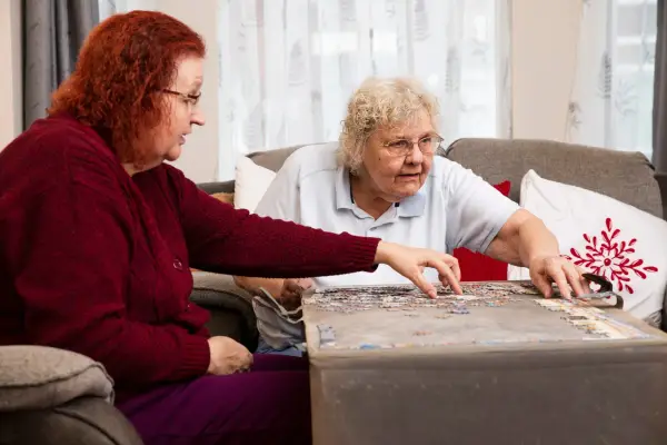 Two elderly women playing puzzle