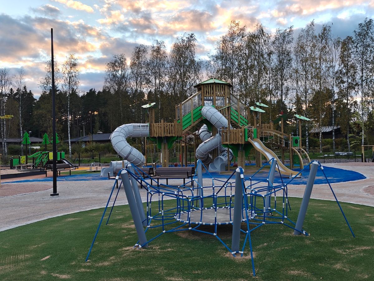 Etualalla trampoliini, taustalla iso kiipeilyteline.