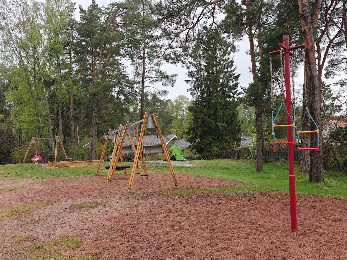 Juoksukaruselli, taustalla keinuja ja hiekkalaatikko.