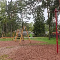 Juoksukaruselli, taustalla keinuja ja hiekkalaatikko.