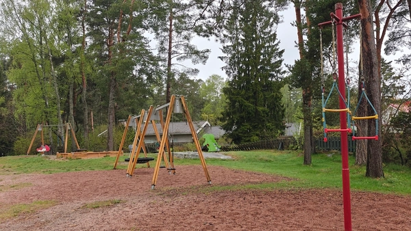 Juoksukaruselli, taustalla keinuja ja hiekkalaatikko.