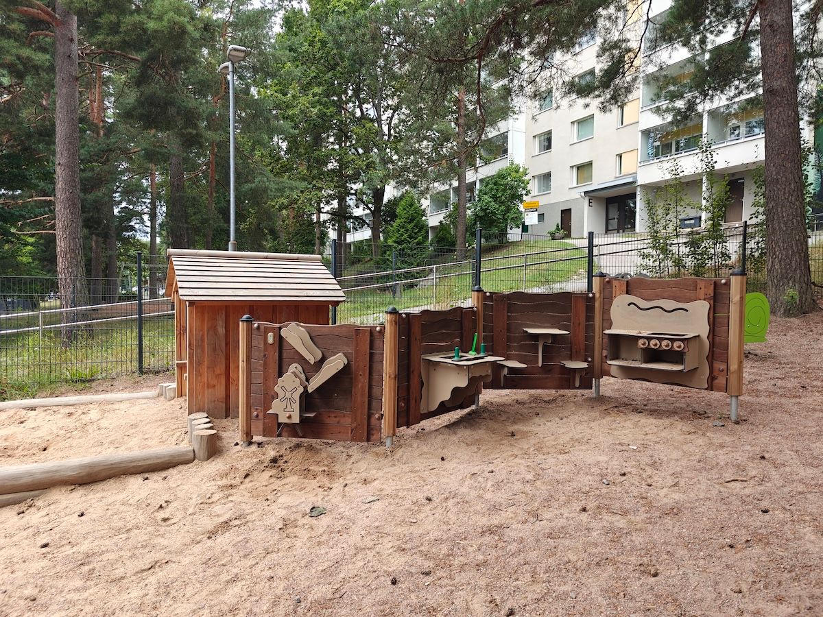 Hiekkalaatikko ja monipuolinen leikkikeittiöalue.