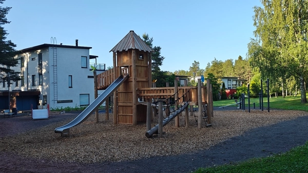 Puinen, linnamainen kiipeilyteline, jossa liukumäki.
