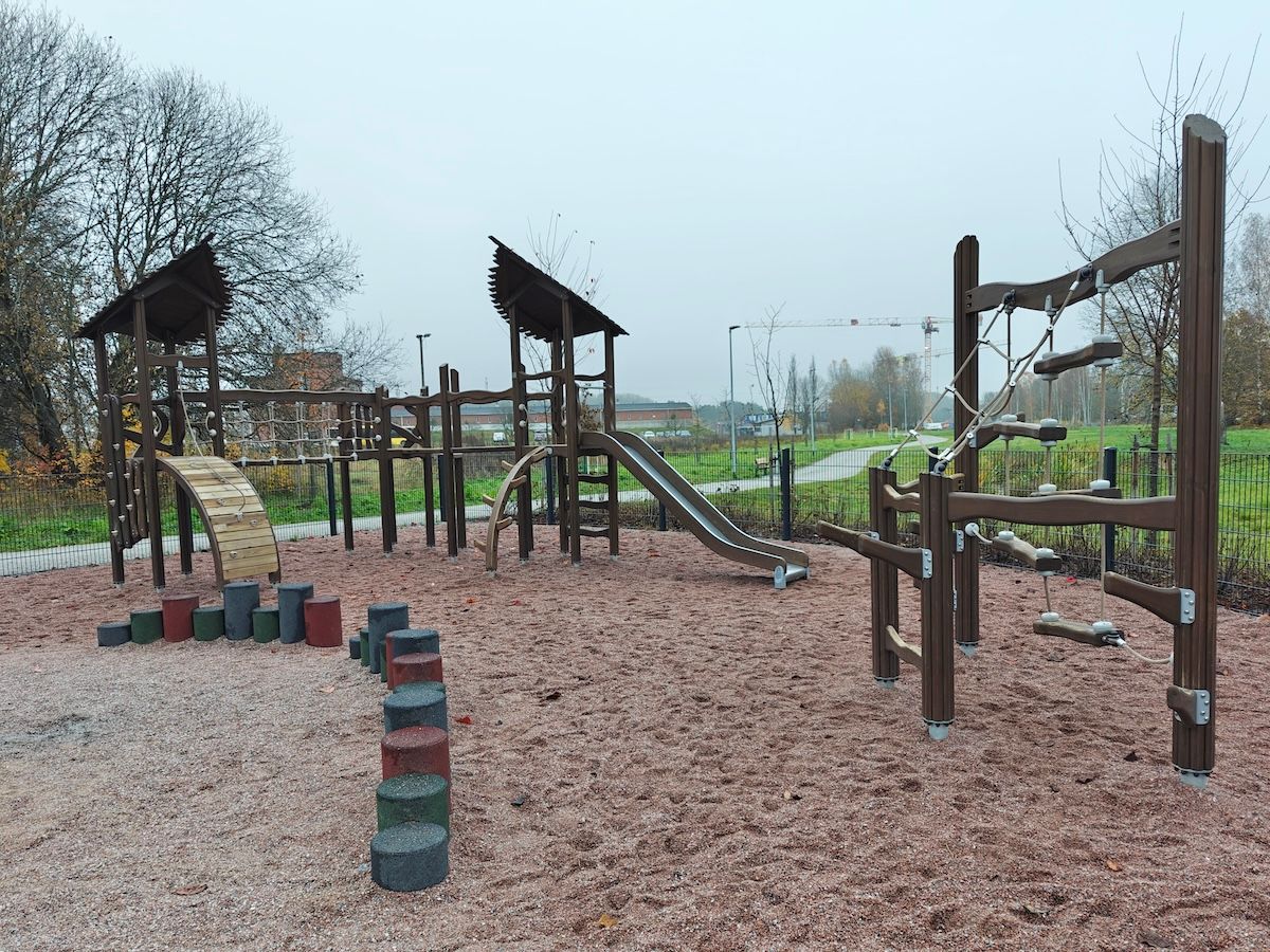 Kaksi kiipeilytelinettä, toisessa liukumäki.