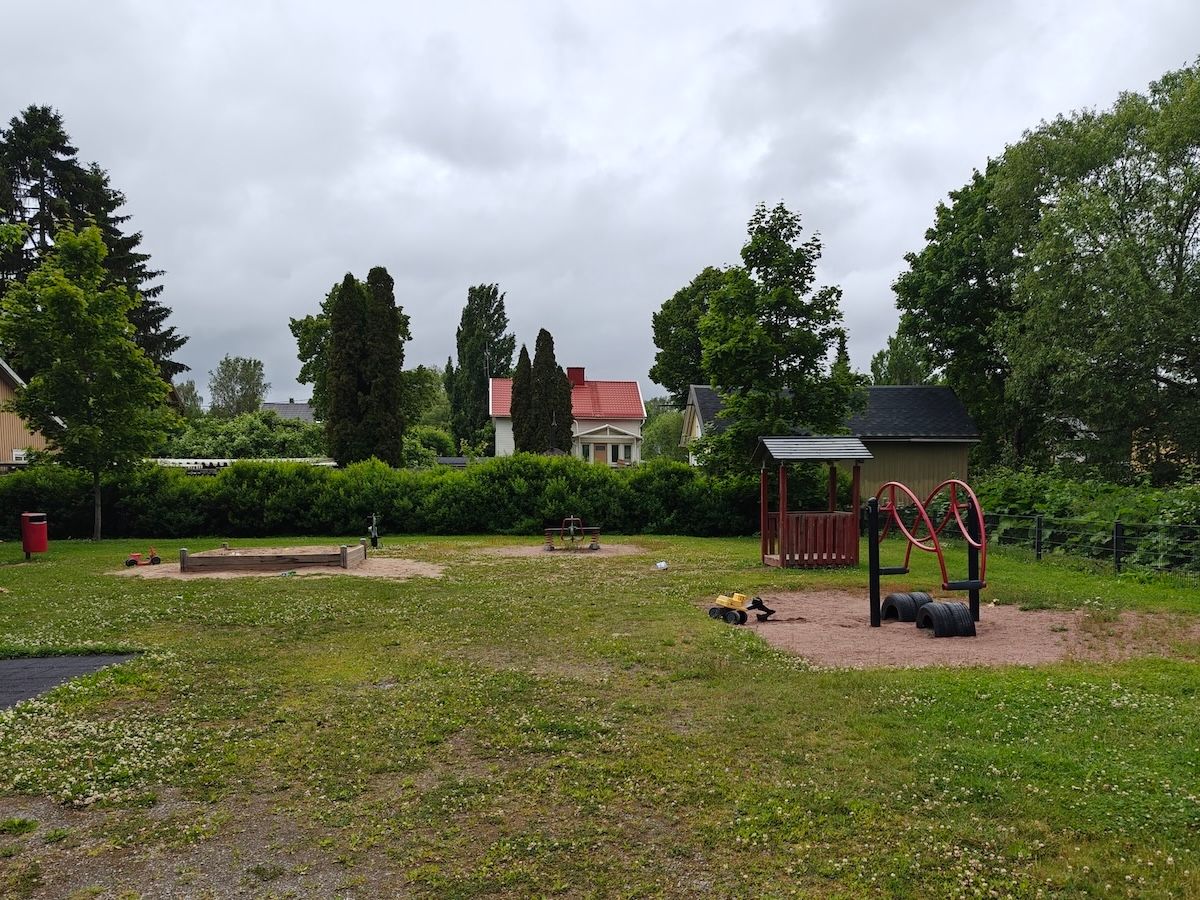 Hiekkalaatikko, katos ja keinuväline.