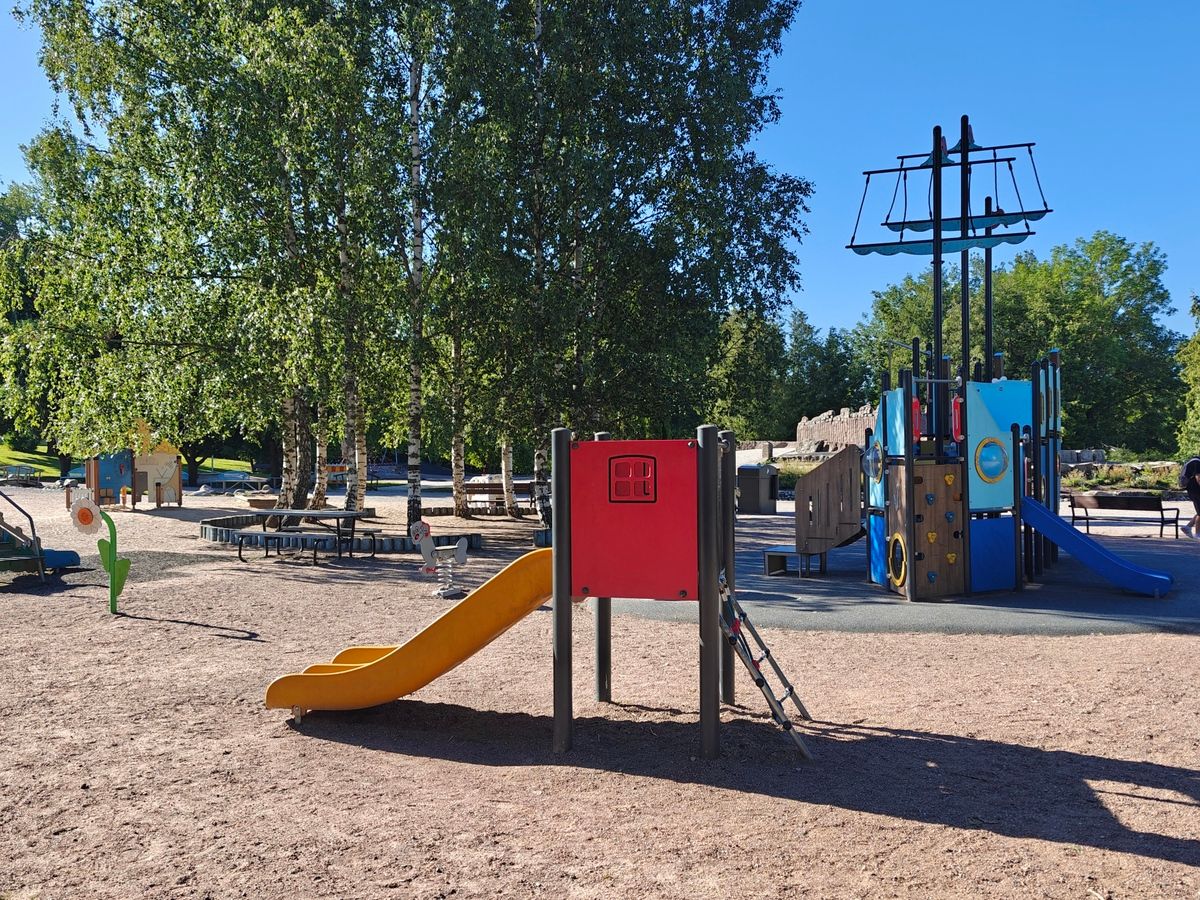 Pieni liukumäki, taustalla laivateemainen kiipeilyteline.