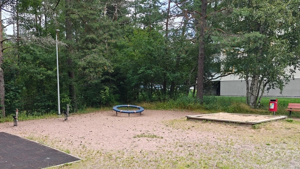 Kaksi jousivälinettä, hiekkalaatikko ja karuselli.