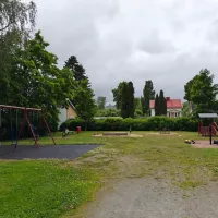 Kaksi lautakeinua, vauvakeinu, jousiväline, hiekkalaatikko, katos ja keinuväline.