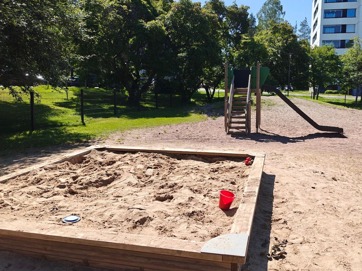 Hiekkalaatikko ja liukumäki.