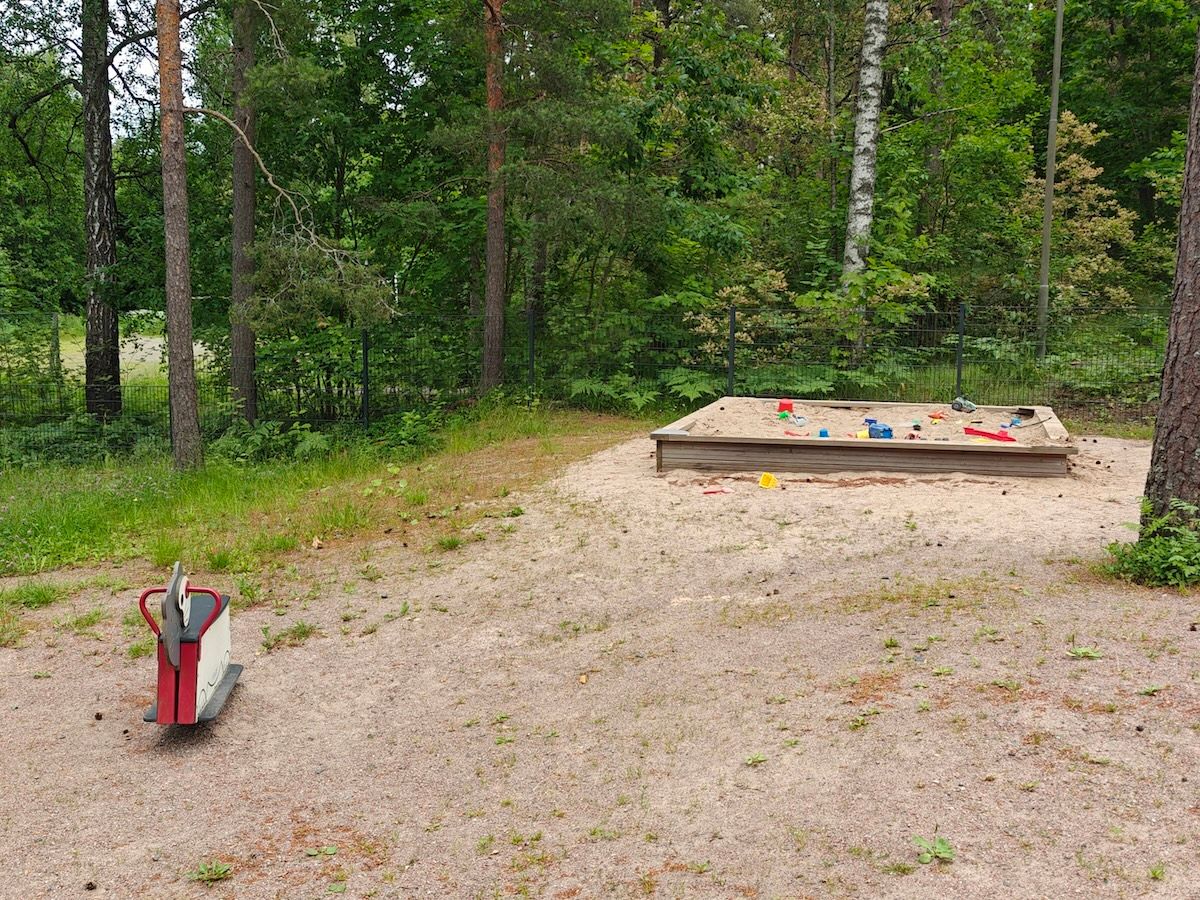 Jousiväline ja hiekkalaatikko.