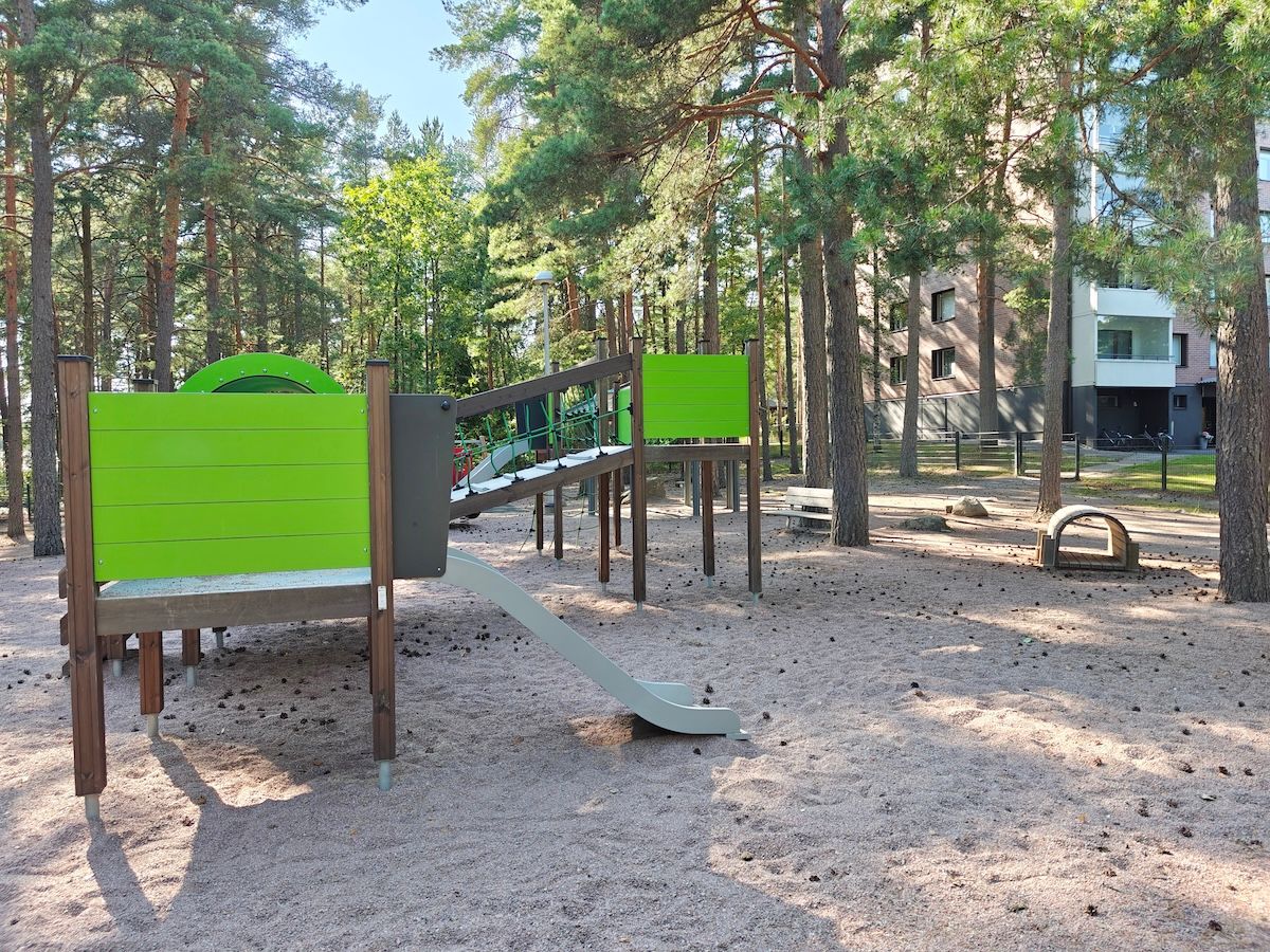 Kiipeilyteline ja pienempi liukumäki.