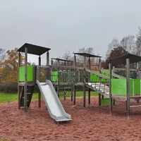 Iso kiipeilyteline, jossa kolme liukumäkeä.