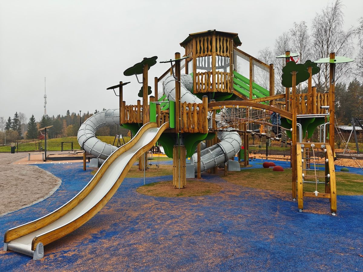 Iso kiipeilyteline, jossa kolme putkiliukumäkeä ja yksi tavallinen liukumäki.