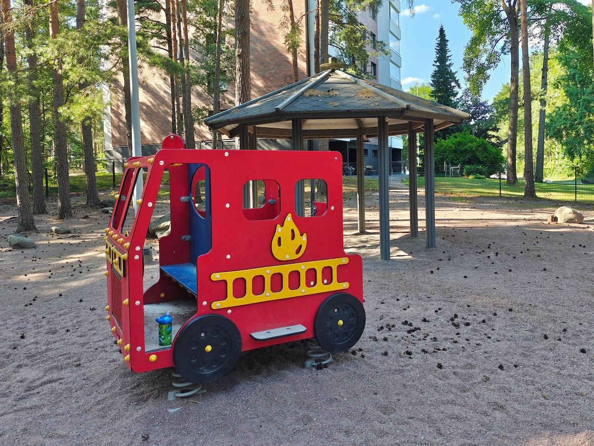 Paloautonmuotoinen leikkiteline.
