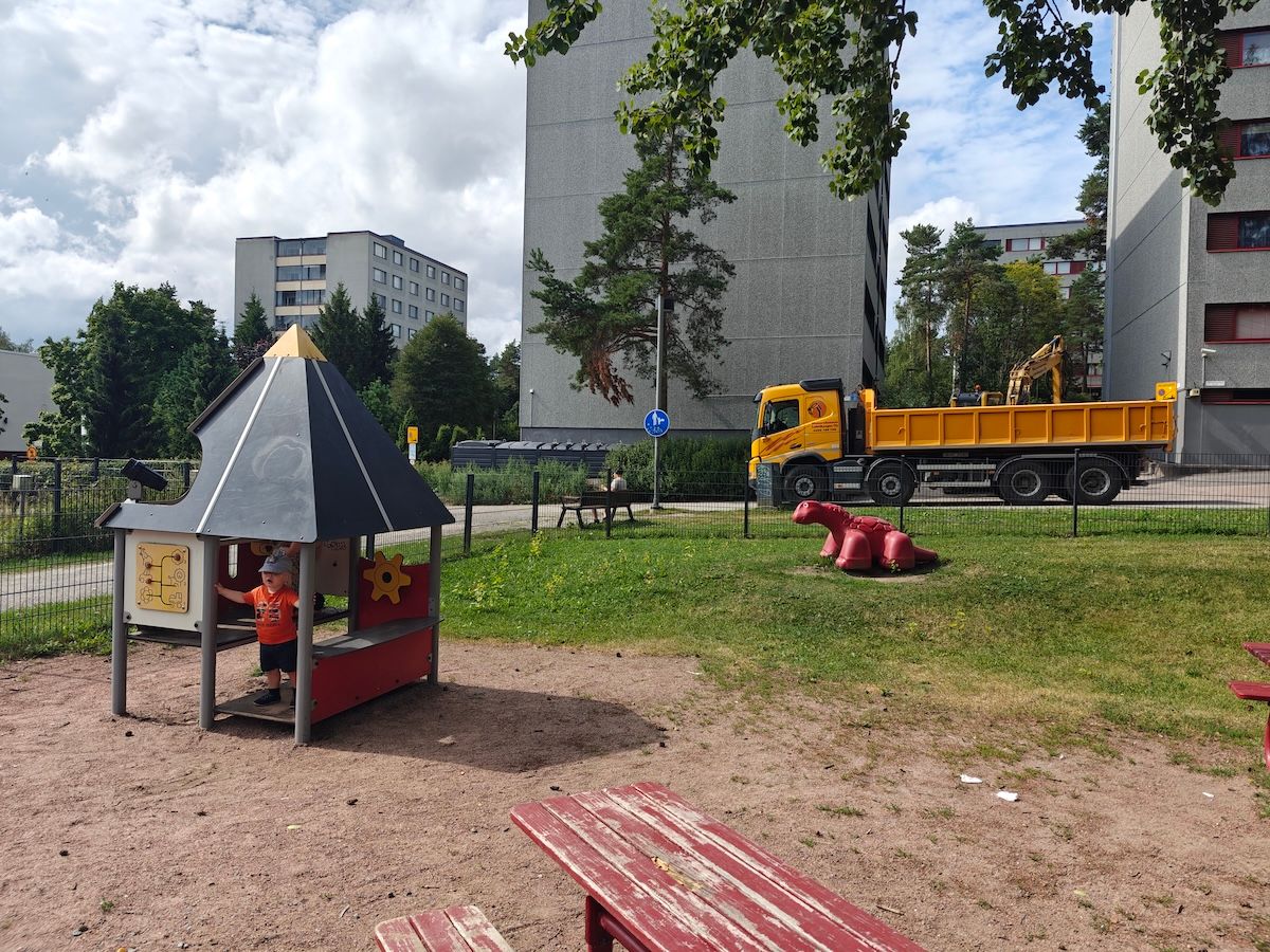 Mökki ja dinosauruspatsas.