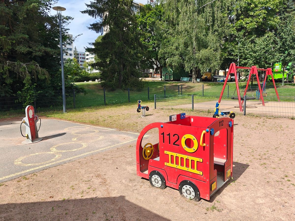Paloauto, keinut ja asfalttikenttä tankkausasemalla omille ajokeille.