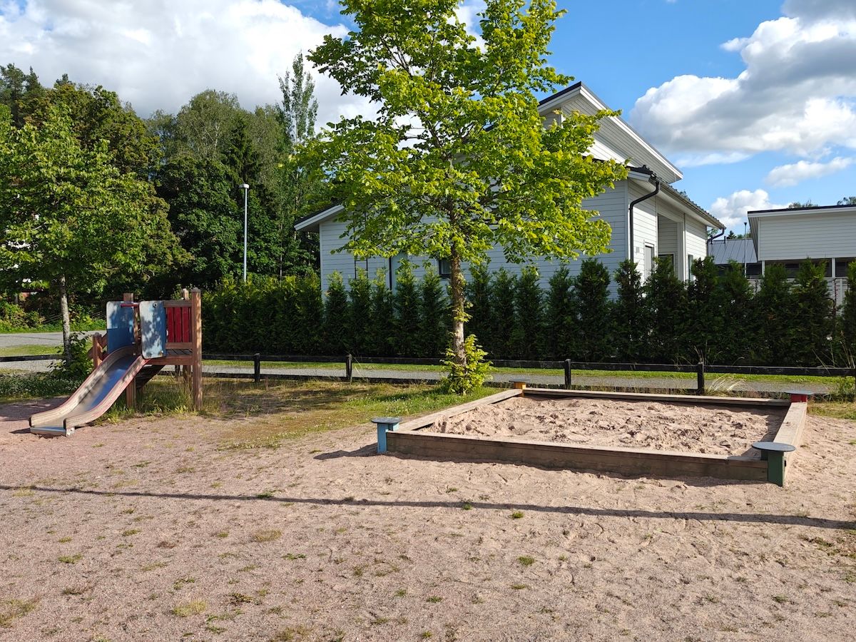 Pieni liukumäki ja hiekkalaatikko.