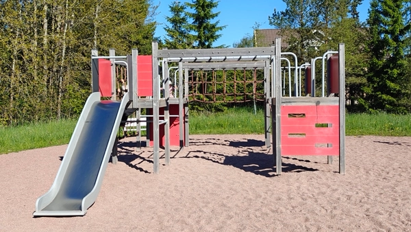 Kiipeilyteline, jossa liukumäki ja paljon erilaisia seiniä ja verkkoja kiipeiltäväksi.