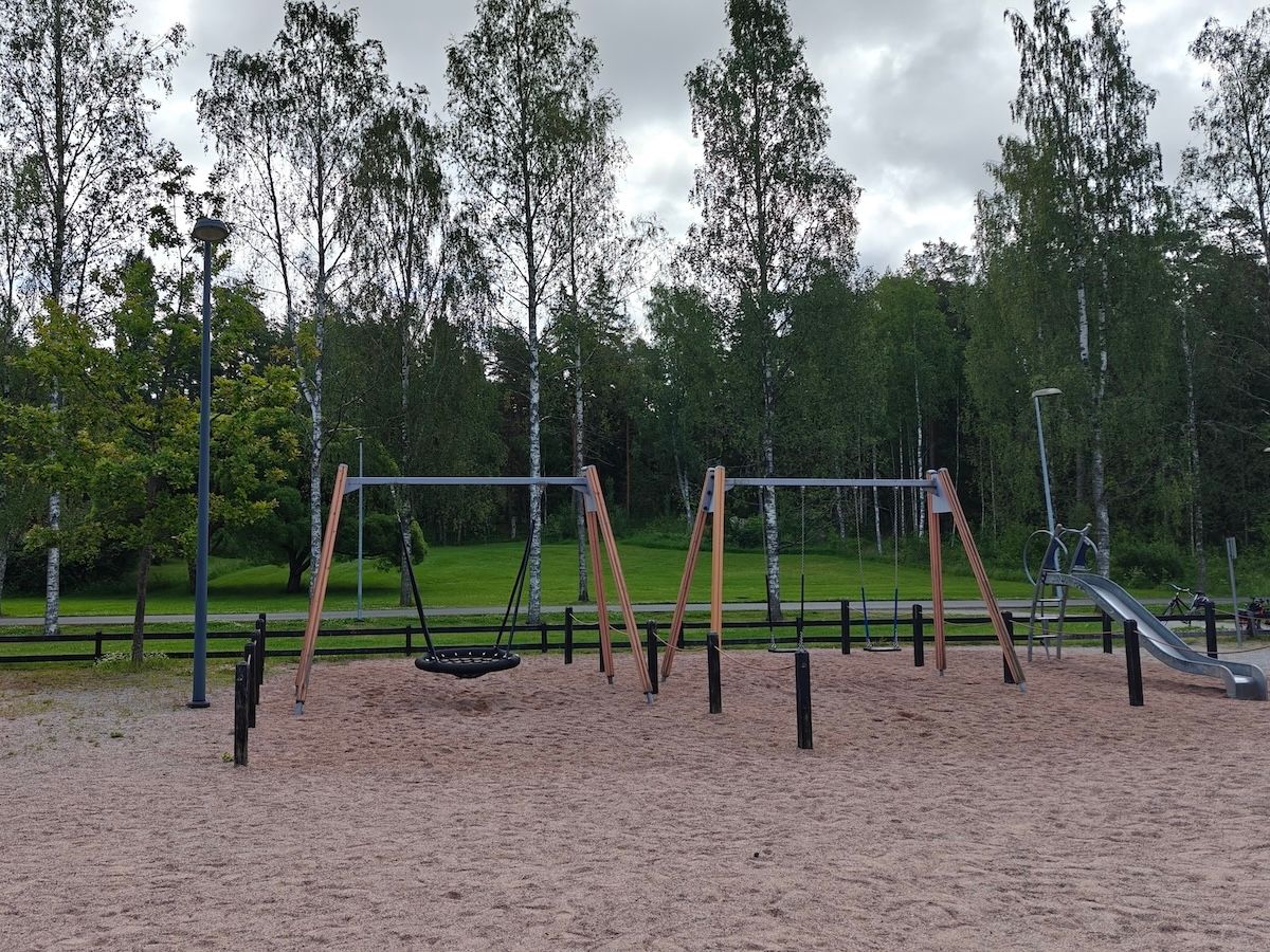 Hämähäkkikeinu, kaksi lautakeinua ja liukumäki.
