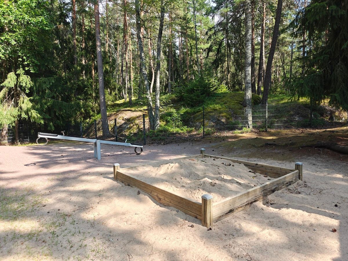 Hiekkalaatikko ja kiikkulauta.