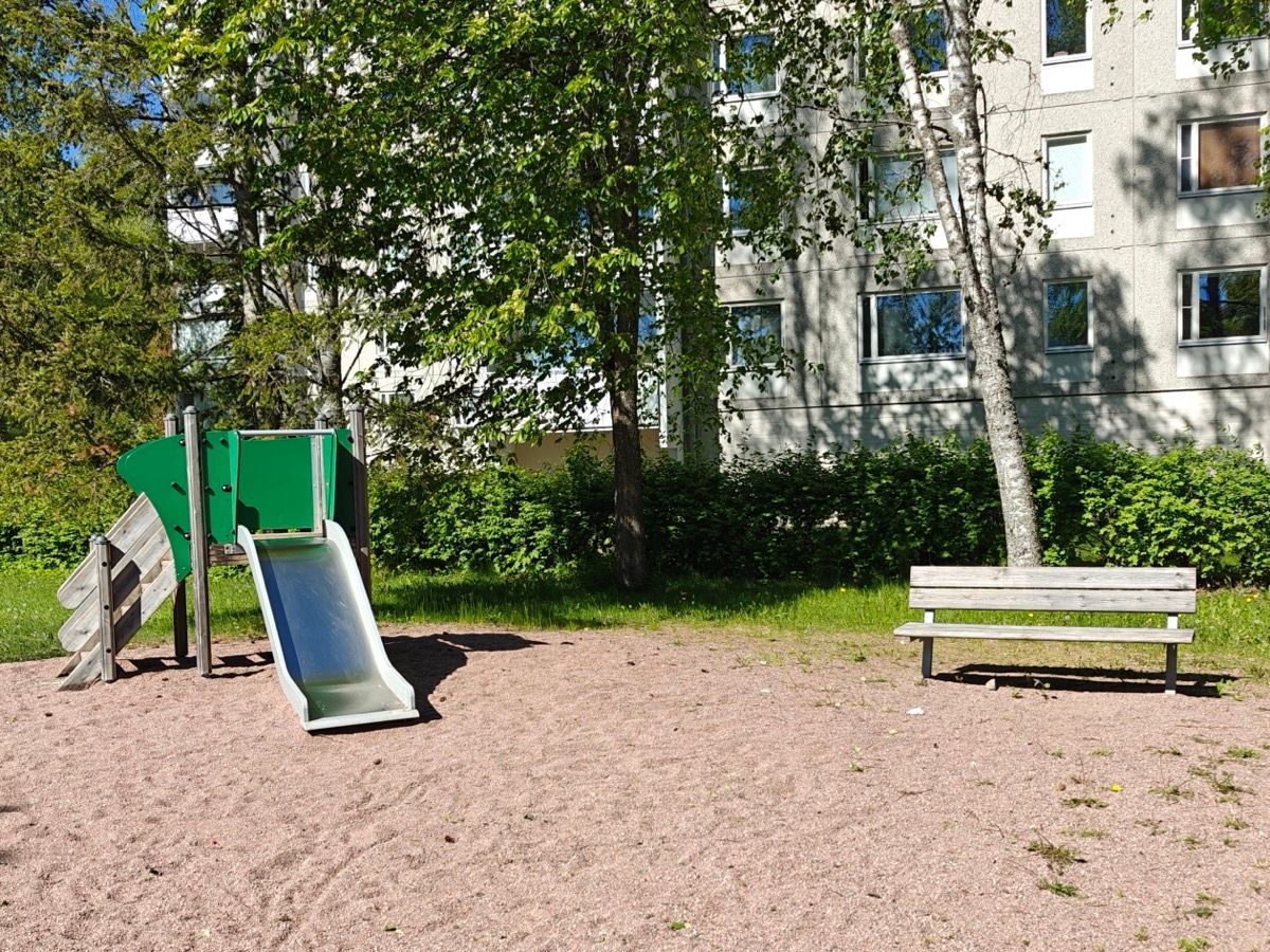 Pieni liukumäki ja penkki.