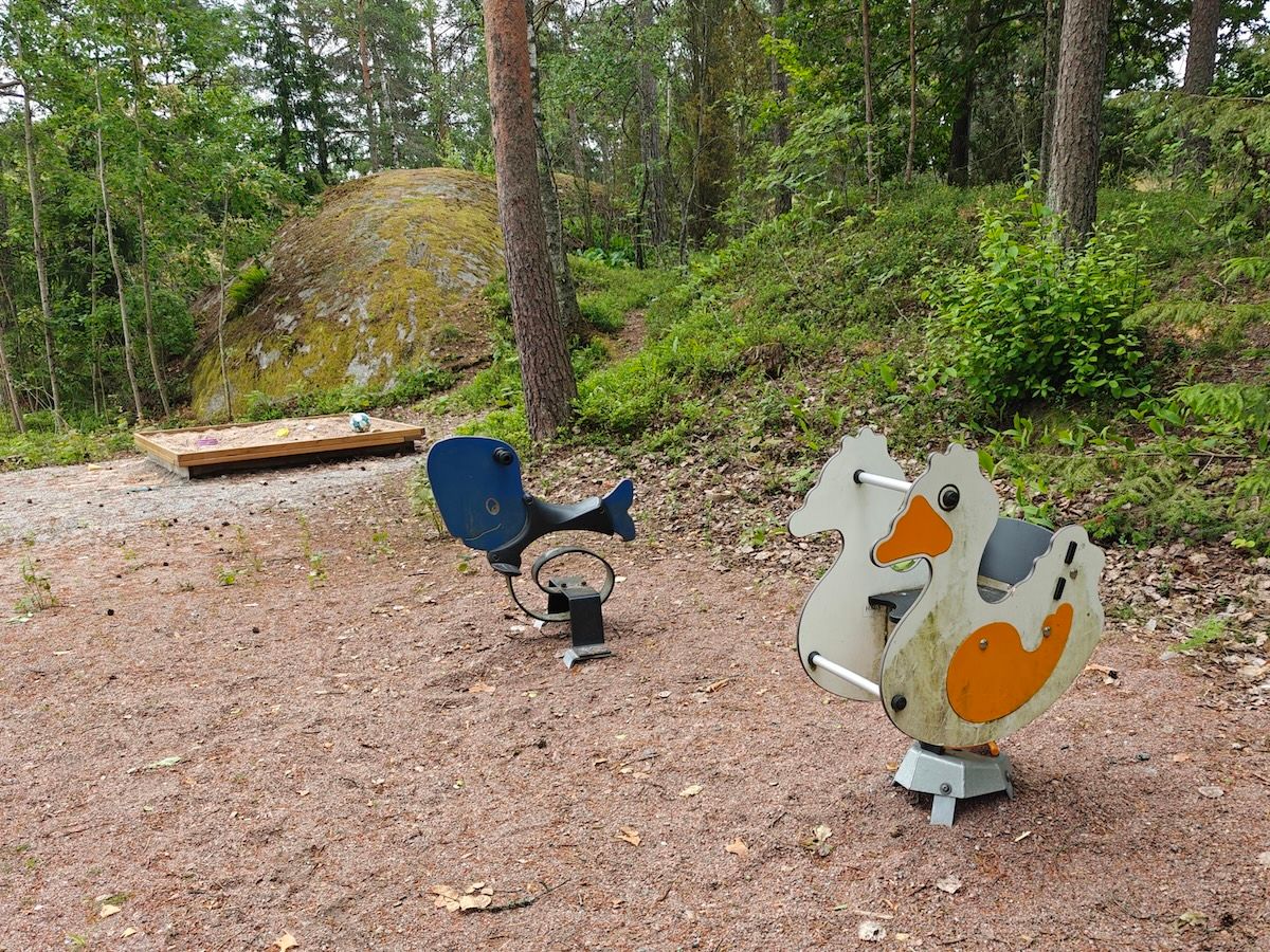 Hiekkalaatikko ja kaksi jousivälinettä.