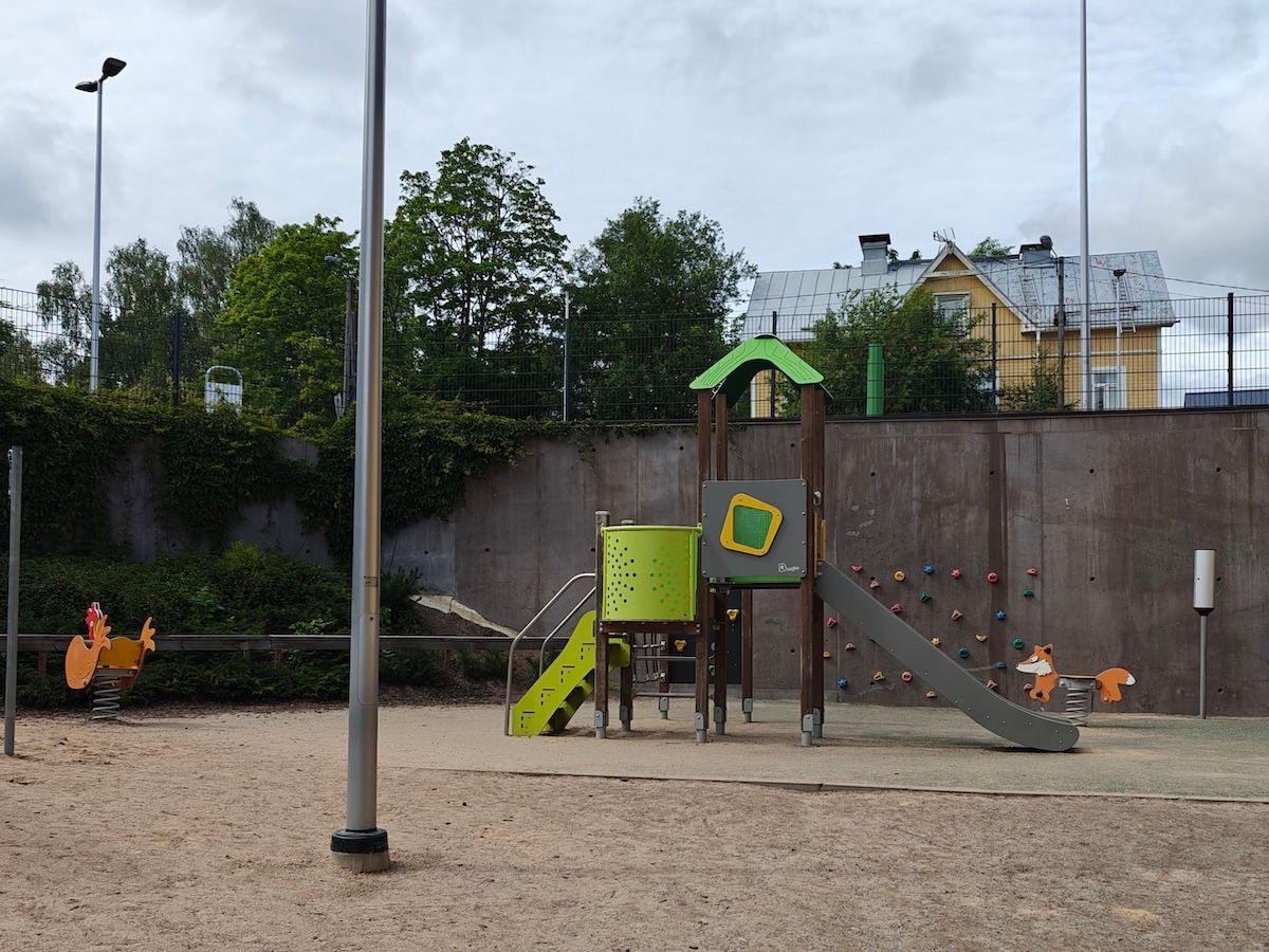 Kaksi jousivälinettä, kiipeilyseinä sekä kiipeilyteline, jossa liukumäki.