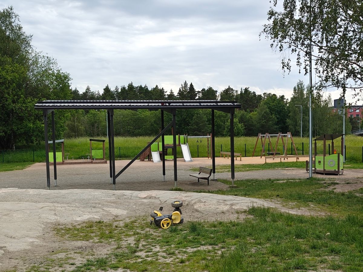Kaukana kiipeilytelineitä, keinuja ja laivanmuotoinen kiipeilyteline.