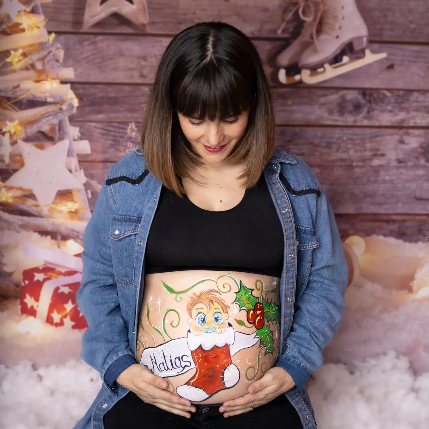 Mujer embarazada con un diseño de bellypainting navideño