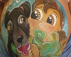 Mujer embarazada con diseño de bellypainting de un bebé militar y su perrito