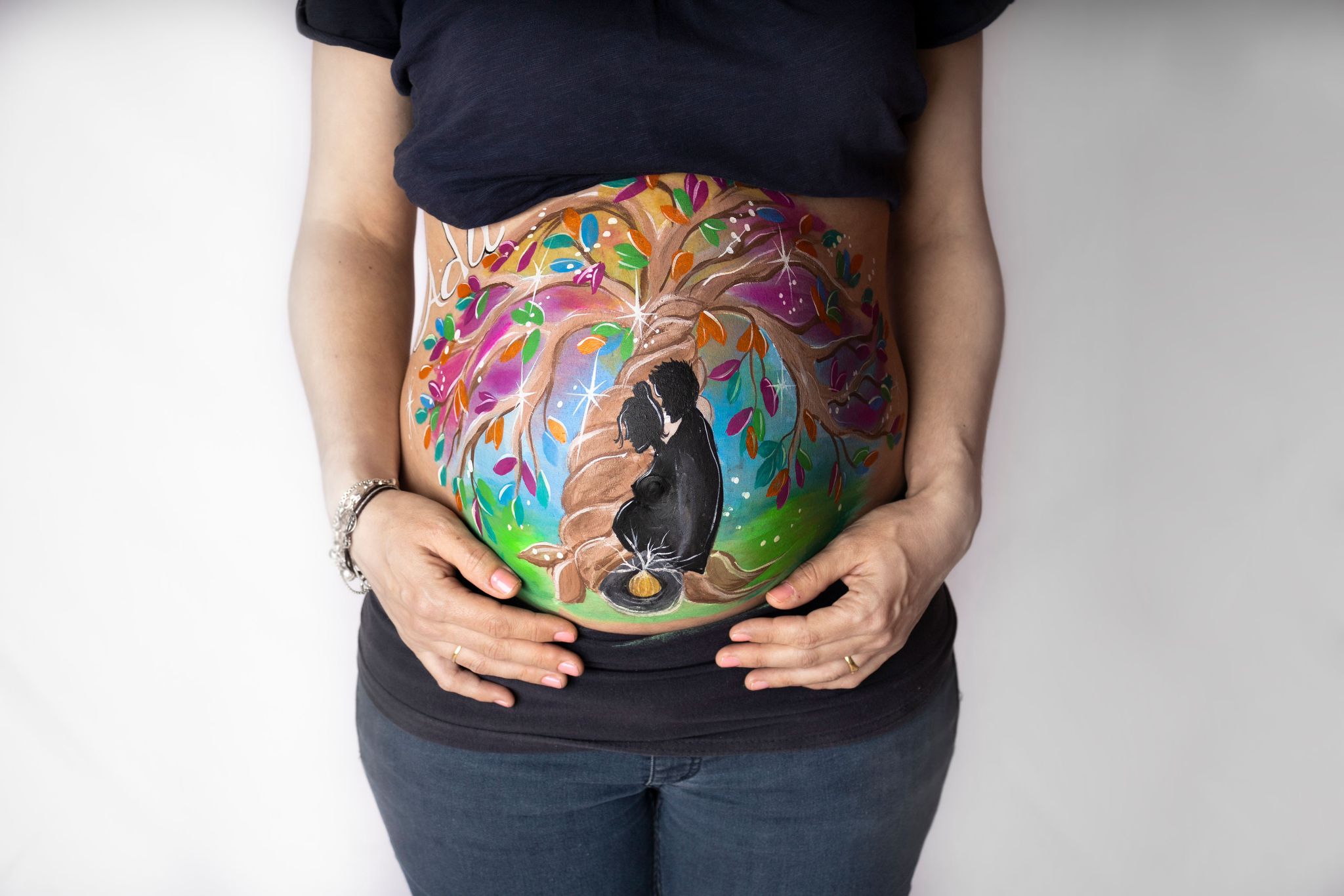 Diseño de bellypainting personalizado, muy colorido con un árbol de la vida y una silueta de un hombre y una mujer embarazada