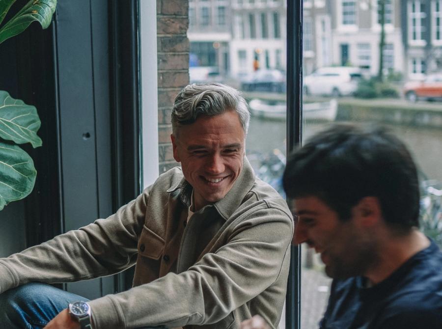 Two colleagues talking by the canal-side window.