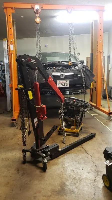 Engine hoist and gantry set up over a car with the front end stripped for an engine and transmission job at Speedy Underhood Service in Columbus, Ohio