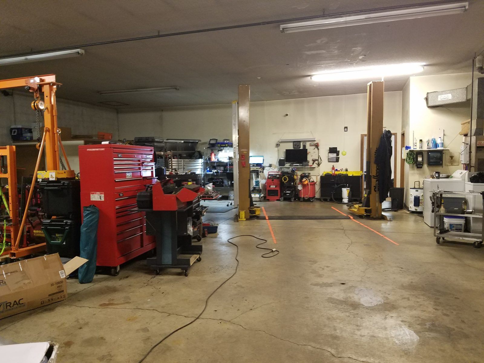Interior view of the service bays with a two-post lift, engine hoist and tool chests at Speedy Underhood Service in Columbus, Ohio